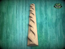 Load image into Gallery viewer, A wooden carving of a spiral pattern is displayed against a green background.
