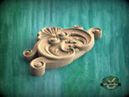 A wooden carving with intricate scrollwork is displayed against a green background.