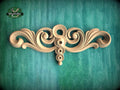 a decorative wooden carving on a green background.