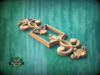A wooden carving of a decorative floral design is displayed against a green background.