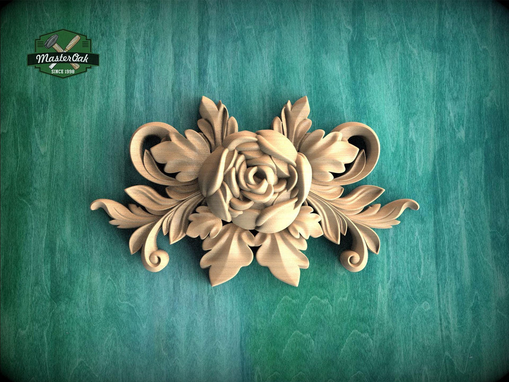 A decorative wooden carving of a flower with leaves is displayed against a green background.