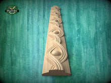 Load image into Gallery viewer, a wooden carving of a decorative design on a wooden surface, set against a green background.
