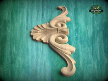 Load image into Gallery viewer, A decorative wooden carving with an intricate, swirling design is displayed against a green background.

