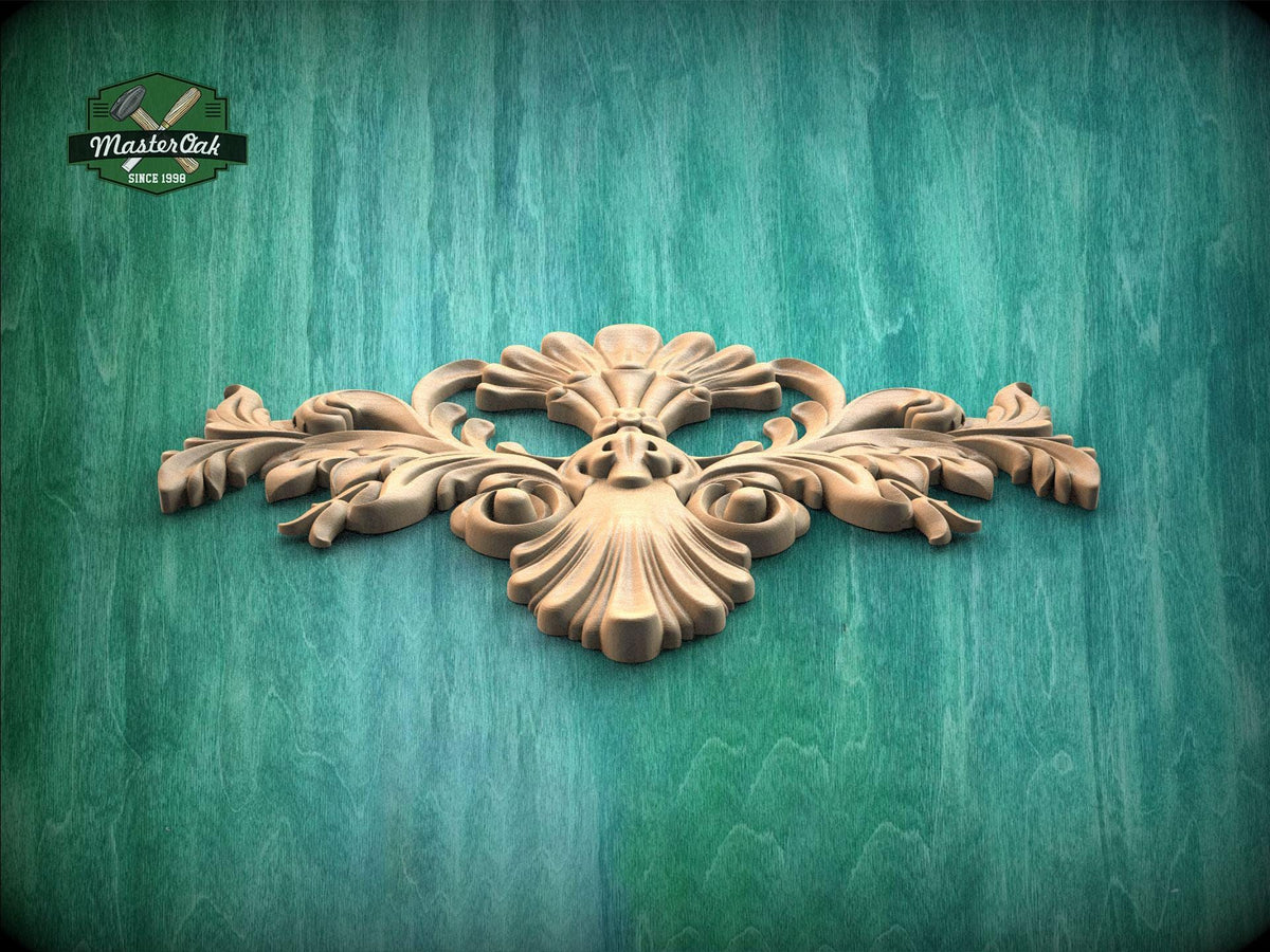 A decorative wooden carving with intricate floral and leaf-like patterns is displayed against a green wooden background.