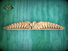 Load image into Gallery viewer, A decorative wooden carving of a leaf-like design is displayed against a green textured background.
