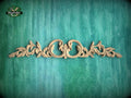 a decorative wooden carving on a green textured background.