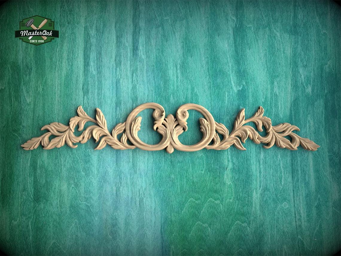 a decorative wooden carving on a green textured background.