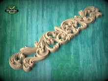 Load image into Gallery viewer, A decorative wooden carving with intricate scrollwork is displayed against a teal background.
