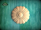 A wooden flower-shaped object is centered against a green background.