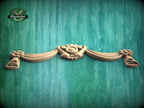 A wooden carving of a heart-shaped design is displayed against a green wooden background.