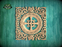 Load image into Gallery viewer, a square, ornately carved wooden cross with intricate floral designs surrounding it, set against a teal background.
