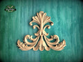 a decorative wooden carving on a green background.