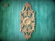 Load image into Gallery viewer, an ornate, carved wooden panel with intricate floral and scroll designs, mounted on a green textured wall.
