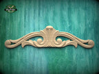 a decorative wooden carving on a green wooden surface.