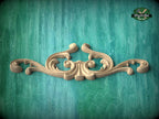 A decorative wooden carving in the shape of a scroll adorns a turquoise background.