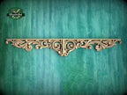 a decorative wooden panel with an intricate, ornate design on a green background.