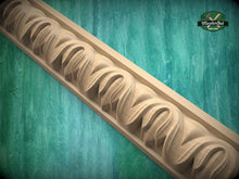 Load image into Gallery viewer, A decorative wooden molding with a repeating pattern of curved lines against a green background.
