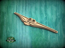 Load image into Gallery viewer, A decorative wooden object with an ornate design is displayed against a green textured background.
