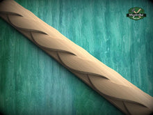 Load image into Gallery viewer, A wooden carving with a curved, braided design is displayed against a green textured background.
