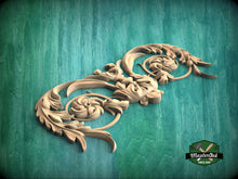 Load image into Gallery viewer, A decorative wooden carving with intricate floral and leaf-like patterns is displayed against a green background.
