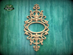 an ornate, carved wooden frame with an oval shape in the center, set against a green background.