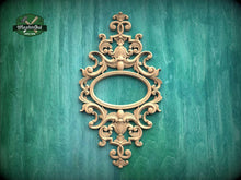 Load image into Gallery viewer, an ornate, carved wooden frame with an oval shape in the center, set against a green background.
