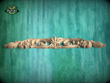 Load image into Gallery viewer, A decorative wooden carving with a floral design is displayed against a textured green background.
