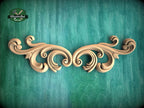 a wooden carving of an ornate design on a green background