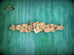 a wood carving of a flower on a green background