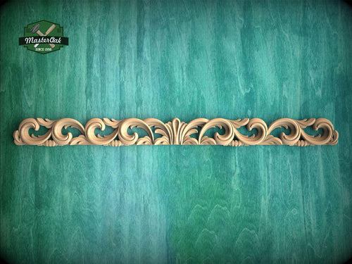 a green wall with a wooden carving on it