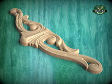 Load image into Gallery viewer, A wooden carving with an intricate, decorative design is displayed against a green background.
