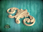 A carved wooden ornament with an intricate, swirling design is displayed against a green background.