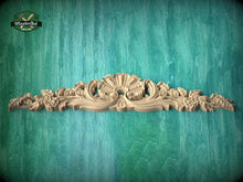 Load image into Gallery viewer, A decorative wooden carving with intricate floral and leaf-like patterns is displayed against a textured green background.
