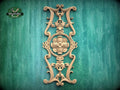 an ornate, carved wooden piece with intricate designs and patterns, mounted on a green wooden surface.