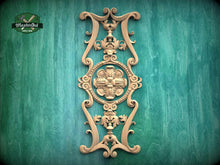 Load image into Gallery viewer, an ornate, carved wooden piece with intricate designs and patterns, mounted on a green wooden surface.
