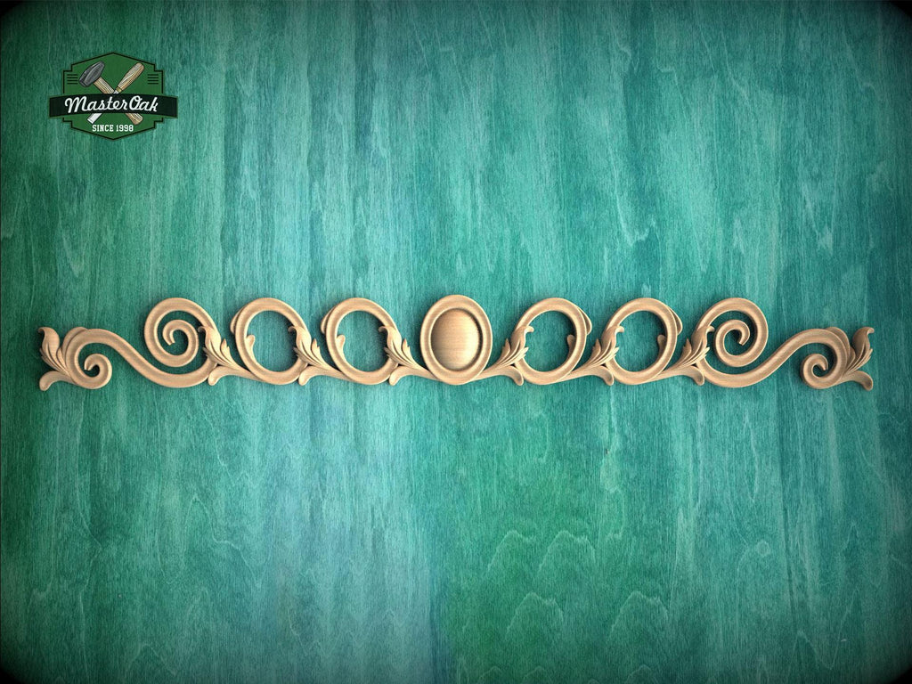 a decorative wooden piece with a floral design, placed against a green background.