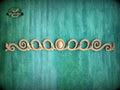 a decorative wooden piece with a floral design, placed against a green background.