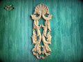 a decorative wooden carving on a green textured background.