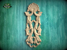 Load image into Gallery viewer, a decorative wooden carving on a green textured background.
