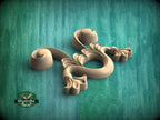 A wooden carving of a stylized floral design is displayed against a teal background.