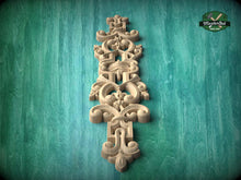 Load image into Gallery viewer, an ornate, carved wooden piece with intricate designs and patterns, set against a green background.
