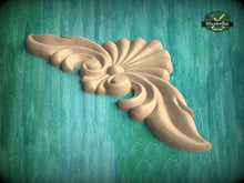 Load image into Gallery viewer, A wooden carving of a stylized leaf or flower design is displayed against a teal background.
