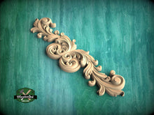 Load image into Gallery viewer, A decorative wooden carving with intricate scrollwork is displayed against a teal background.
