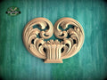 a decorative wooden carving of a heart shape, with intricate scrollwork and floral elements, set against a green background.