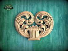 Load image into Gallery viewer, a decorative wooden carving of a heart shape, with intricate scrollwork and floral elements, set against a green background.
