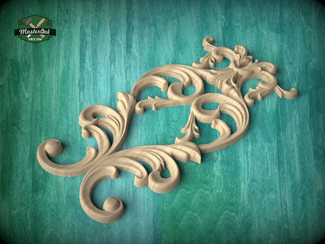 a decorative wooden carving with intricate scrollwork and floral elements, set against a green wooden background.