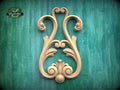 a decorative wooden carving on a green background.