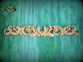 a decorative wooden carving on a green textured background.