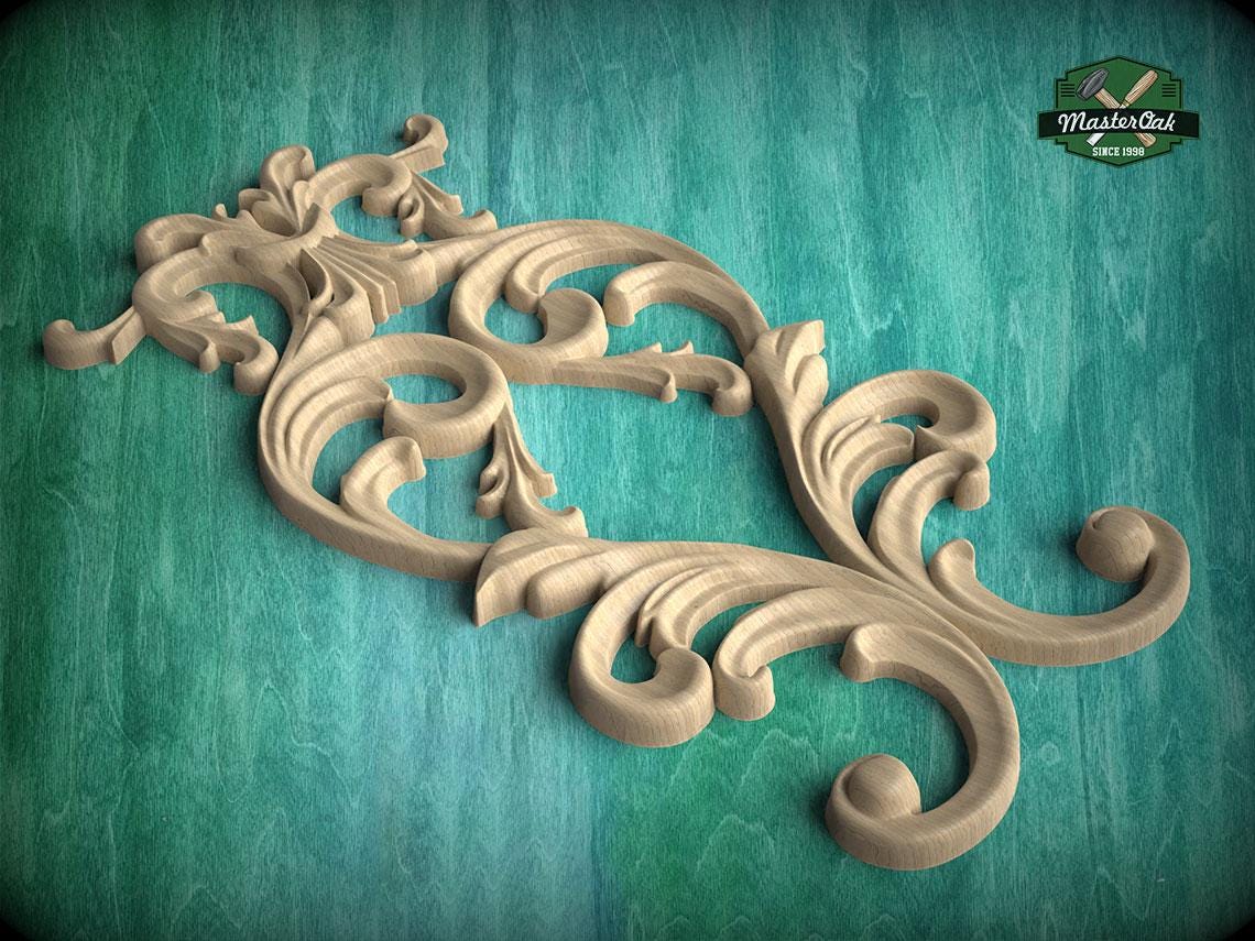 A decorative wooden carving with intricate scrollwork and floral patterns is displayed against a teal background.