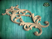 Load image into Gallery viewer, A decorative wooden carving with intricate scrollwork and floral patterns is displayed against a teal background.
